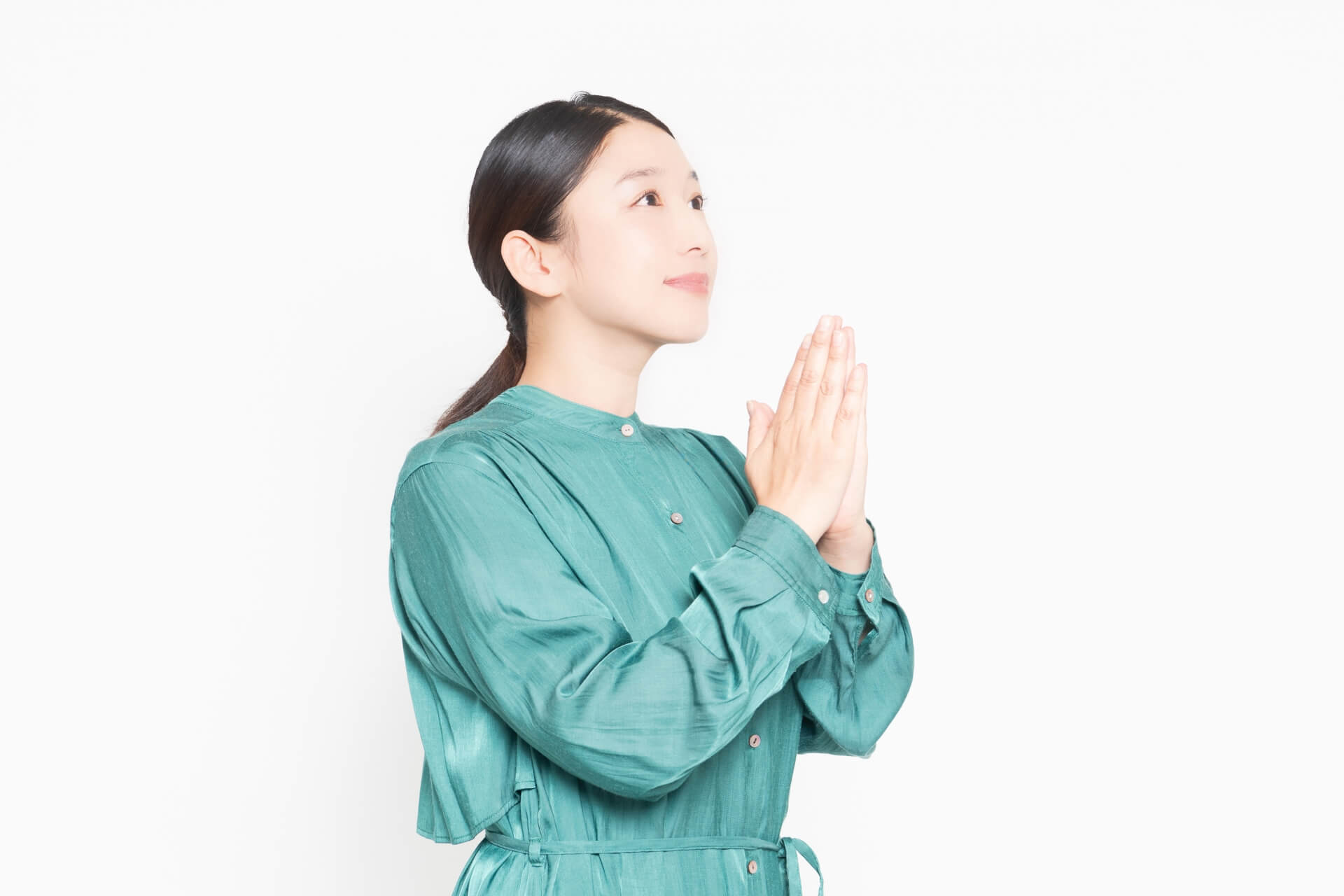 緑の服を着た女性が祈る姿